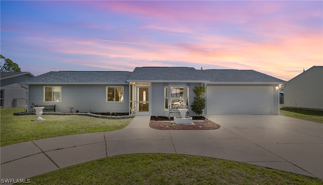 ranch-style house featuring a garage and a yard