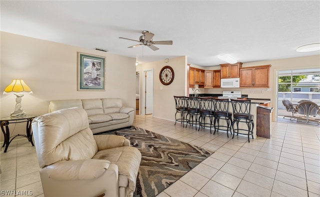 living room with ceiling fan, light tile flooring, and sink