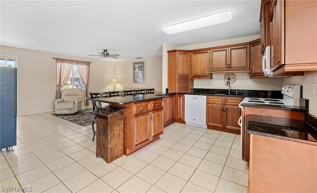 kitchen featuring white appliances, kitchen peninsula, sink, ceiling fan, and light tile floors