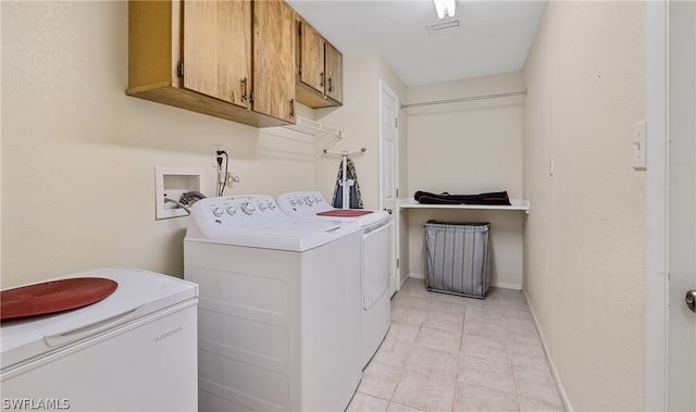 laundry area with hookup for a washing machine, washing machine and clothes dryer, cabinets, and light tile floors