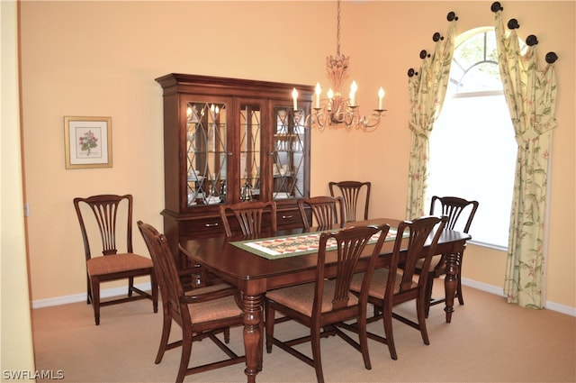 dining area featuring light carpet and a chandelier