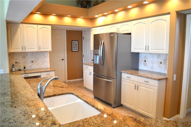 kitchen with sink, backsplash, light tile flooring, and light stone counters