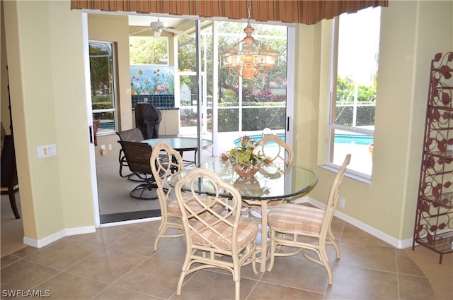 tiled dining area featuring plenty of natural light and ceiling fan with notable chandelier