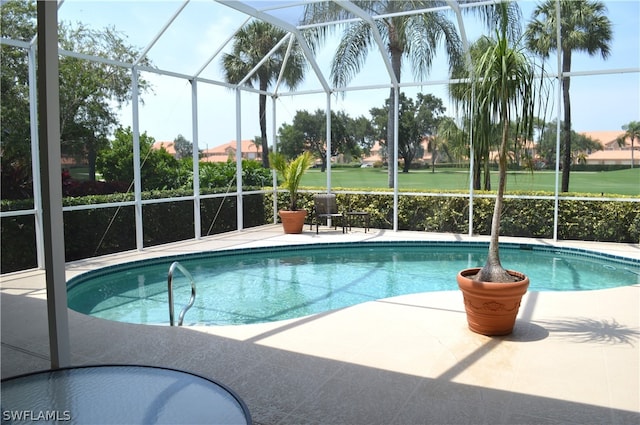 view of pool featuring glass enclosure and a patio