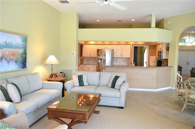 tiled living room with a towering ceiling and ceiling fan