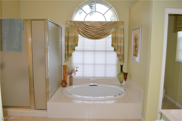 bathroom featuring shower with separate bathtub