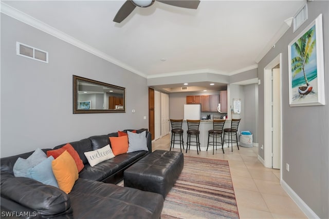 tiled living room with ceiling fan and ornamental molding