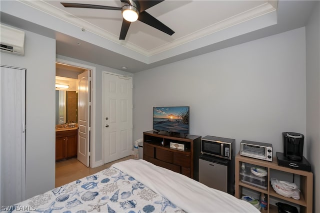 bedroom with fridge, a wall mounted air conditioner, ensuite bathroom, ceiling fan, and a raised ceiling