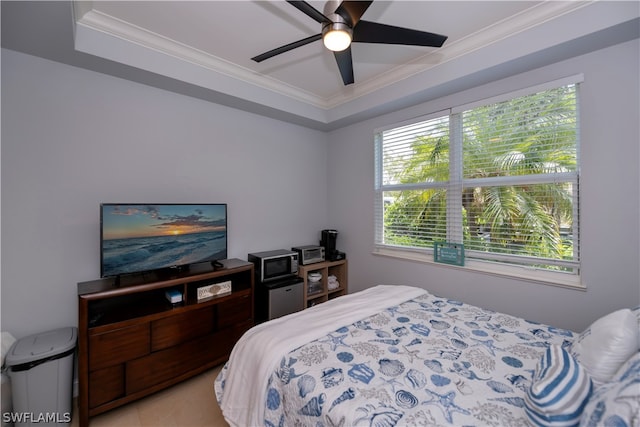 bedroom featuring crown molding, ceiling fan, a tray ceiling, and multiple windows