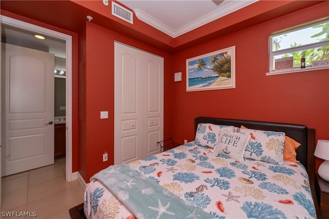 bedroom featuring tile flooring, connected bathroom, ornamental molding, and a closet