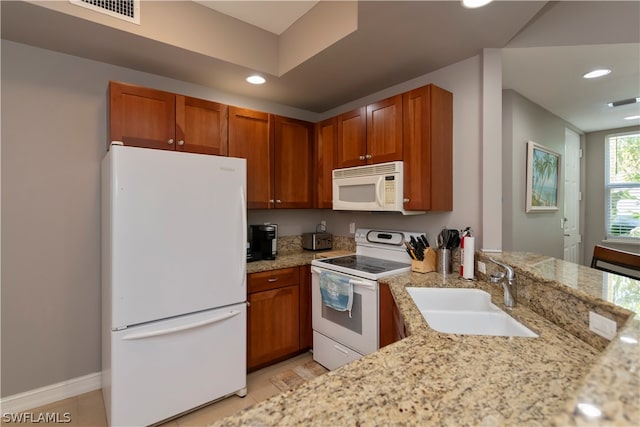 kitchen featuring light stone counters, kitchen peninsula, sink, white appliances, and light tile floors