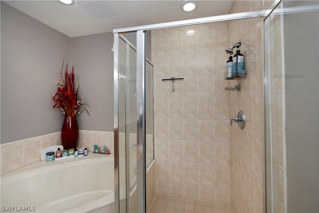 bathroom featuring shower with separate bathtub