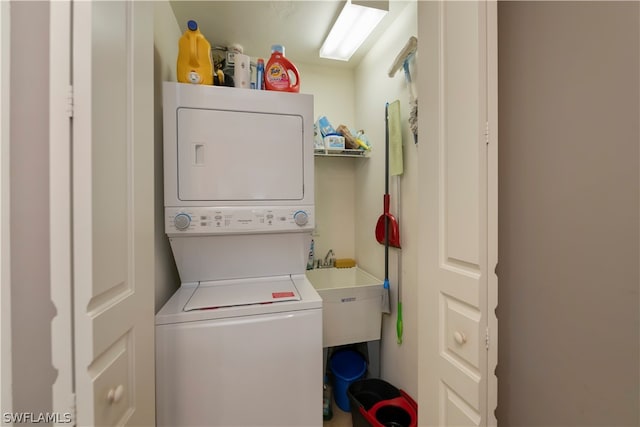 laundry room featuring stacked washing maching and dryer and sink