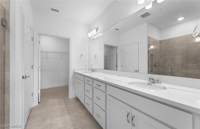 bathroom featuring tile patterned flooring, vanity, and an enclosed shower