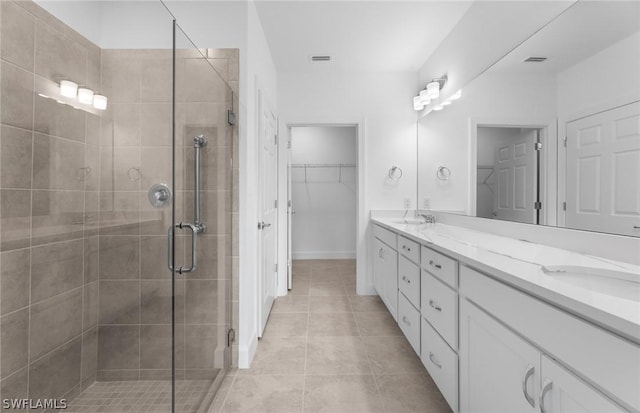 bathroom featuring tile patterned floors, vanity, and a shower with door