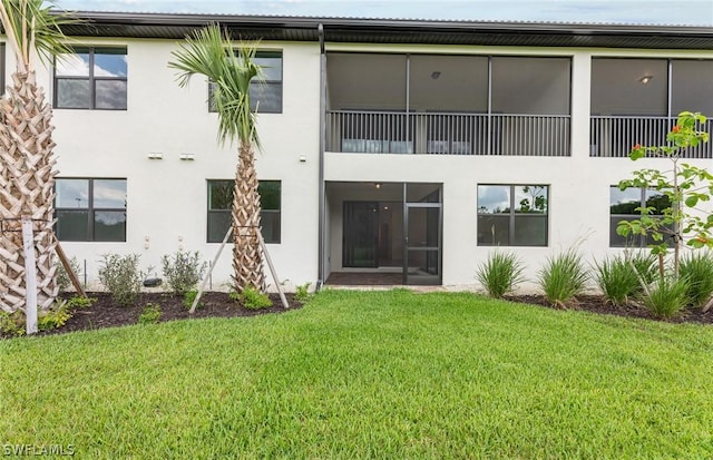 rear view of house featuring a lawn