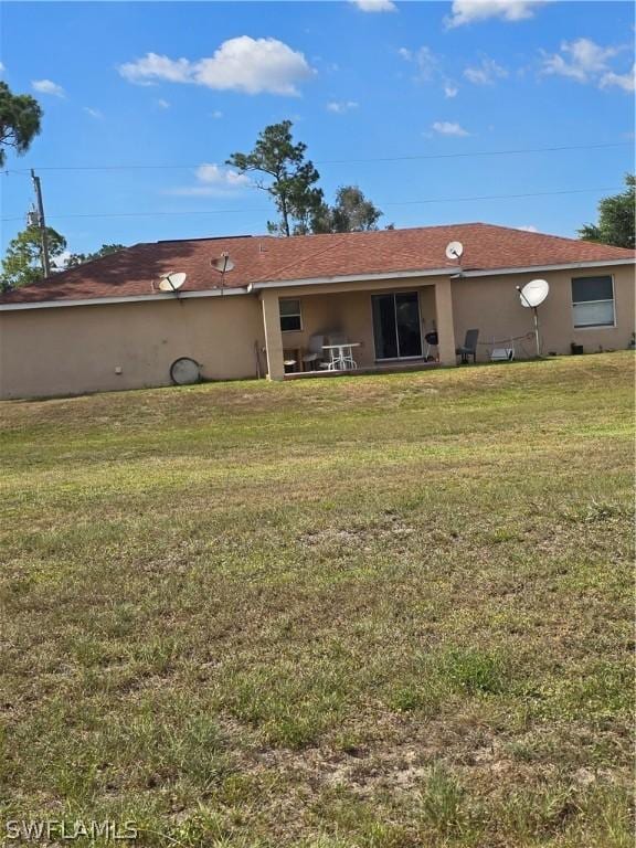 466 Redwing St, Lehigh Acres, FL 33974 - back of property with a lawn and stucco siding