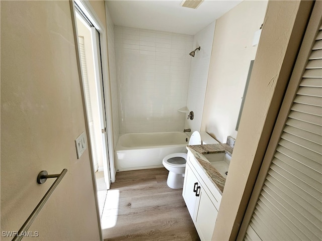 full bathroom featuring vanity, toilet, wood-type flooring, and tiled shower / bath