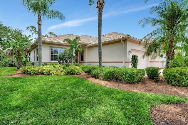 view of front of house with a garage and a front lawn