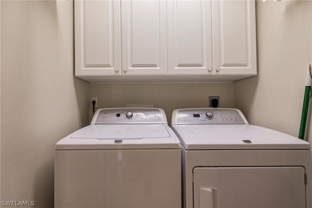 laundry area with independent washer and dryer, hookup for an electric dryer, and cabinets