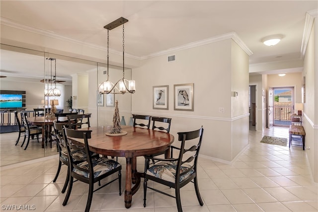 dining room with ornamental molding, light tile floors, and a chandelier