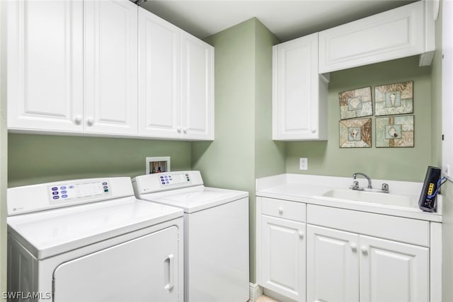 washroom featuring sink, cabinets, and independent washer and dryer