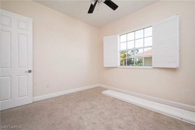 carpeted spare room with ceiling fan