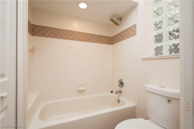 bathroom featuring toilet and tiled shower / bath combo