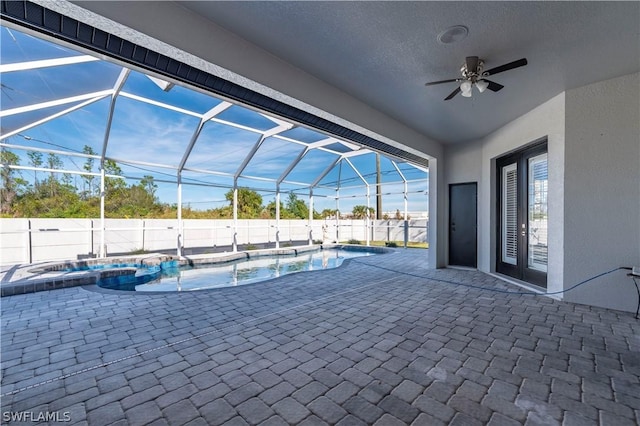 view of pool with an in ground hot tub, glass enclosure, and a patio