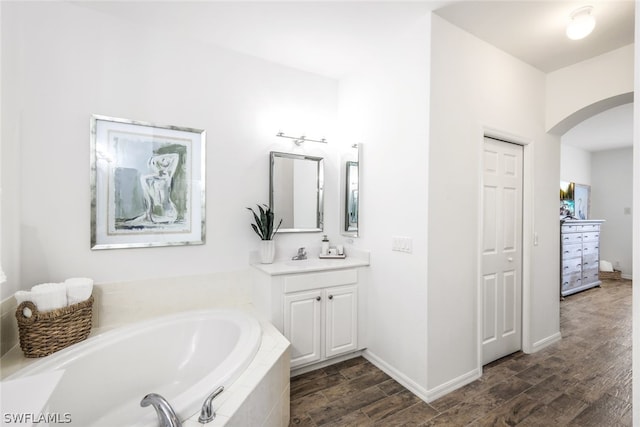 bathroom featuring vanity and tiled bath