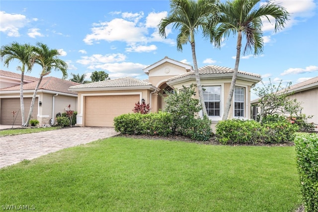 view of front facade with decorative driveway, a tile roof, stucco siding, an attached garage, and a front lawn