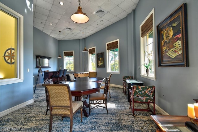 carpeted dining room featuring visible vents, baseboards, and a drop ceiling