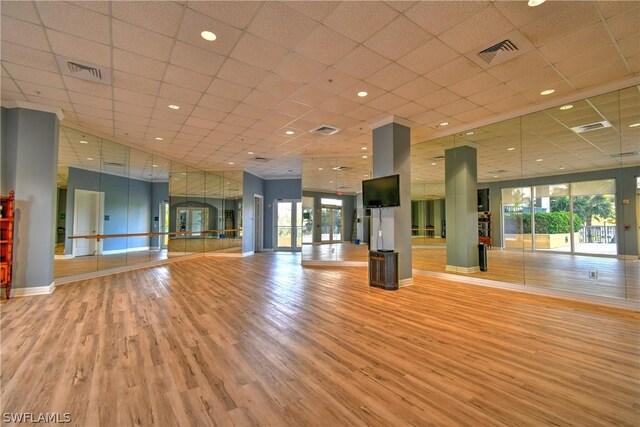 interior space featuring a paneled ceiling, light hardwood / wood-style floors, and a wealth of natural light