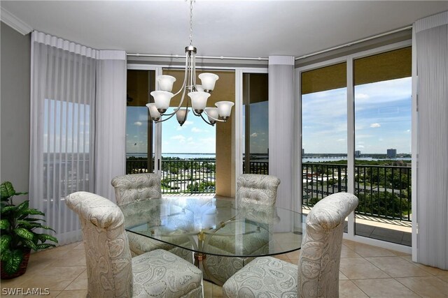 dining area with a chandelier, light tile patterned floors, a water view, and a wall of windows