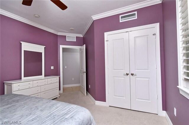 carpeted bedroom with ceiling fan, a closet, and ornamental molding