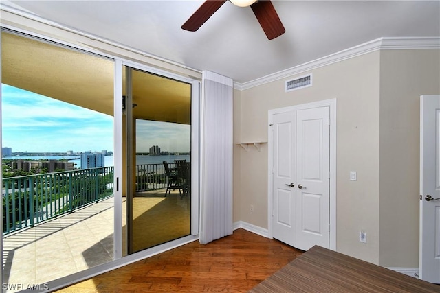 unfurnished bedroom featuring visible vents, ornamental molding, access to exterior, wood finished floors, and ceiling fan