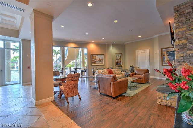 living area with visible vents, recessed lighting, light wood-style floors, crown molding, and baseboards