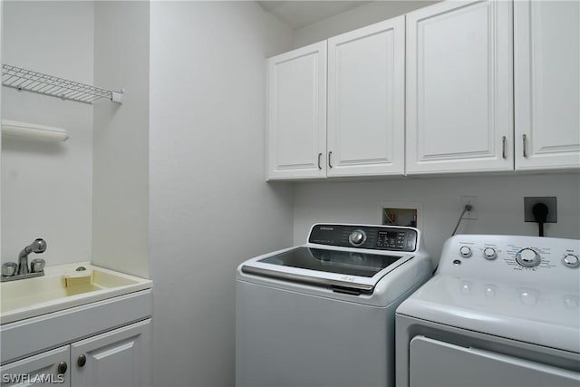 laundry room with a sink, cabinet space, and washer and clothes dryer