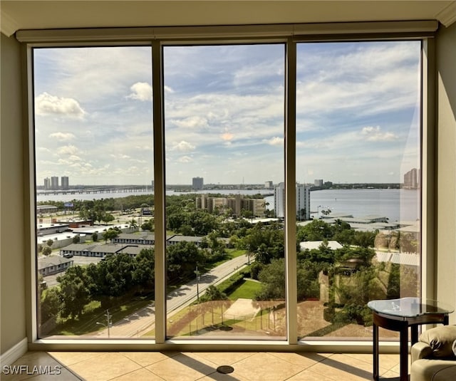 unfurnished sunroom featuring a city view, a healthy amount of sunlight, and a water view