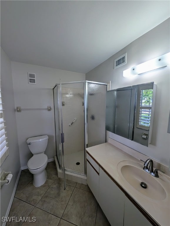 bathroom featuring toilet, vanity, tile patterned floors, and walk in shower