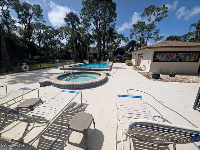 view of swimming pool featuring a community hot tub and a patio