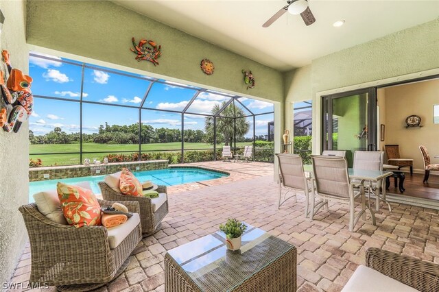 view of pool featuring an outdoor hangout area, glass enclosure, a patio, and ceiling fan