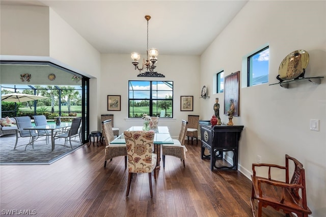 dining room with a wealth of natural light, dark hardwood / wood-style flooring, and a chandelier