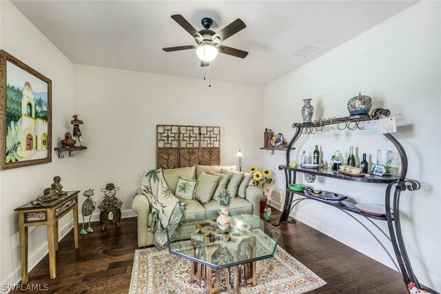 living room with ceiling fan and dark wood-type flooring