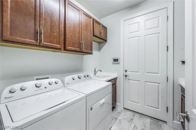 laundry area with washer and clothes dryer, cabinets, and sink