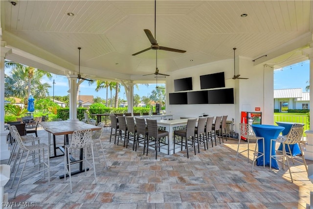 view of patio / terrace featuring ceiling fan and a bar