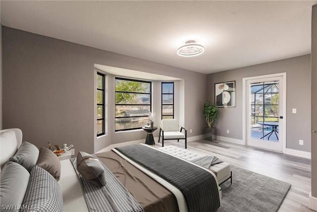 bedroom featuring access to exterior and light hardwood / wood-style flooring