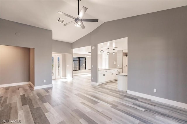 unfurnished living room with lofted ceiling, ceiling fan, and light hardwood / wood-style floors