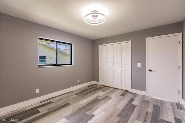 unfurnished bedroom featuring a closet and light hardwood / wood-style flooring