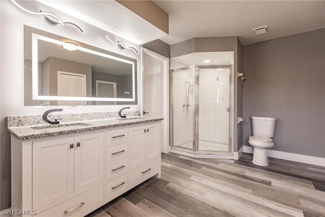 bathroom with toilet, a shower with door, wood-type flooring, and vanity